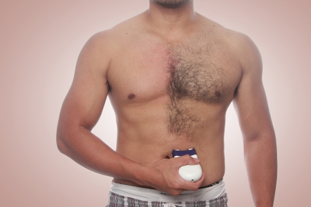 Mann testet Epilierer für Männer und wendet es an Brust an