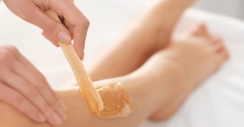 Frau verwendet Warmwachs für ihre Beine