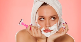 Frau zeigt, wie Gesichtshaare entfernen funktioniert