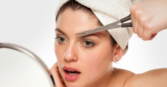 Augenbrauen selber schneiden mit der Augenbrauenschere bei einer Frau