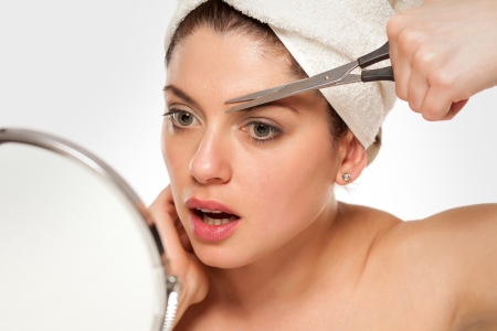 Augenbrauen selber schneiden mit der Augenbrauenschere bei einer Frau