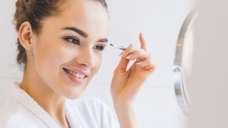 Frau zeigt wie Augenbrauen zupfen funktioniert