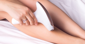 Frau verwendet IPL Haarentfernung an ihren Beinen